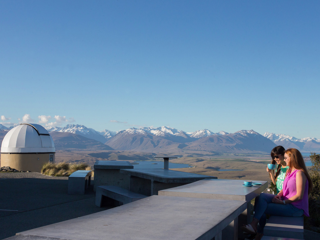 2 people drinking coffee outside Astro Cafe in Lake Tekapo