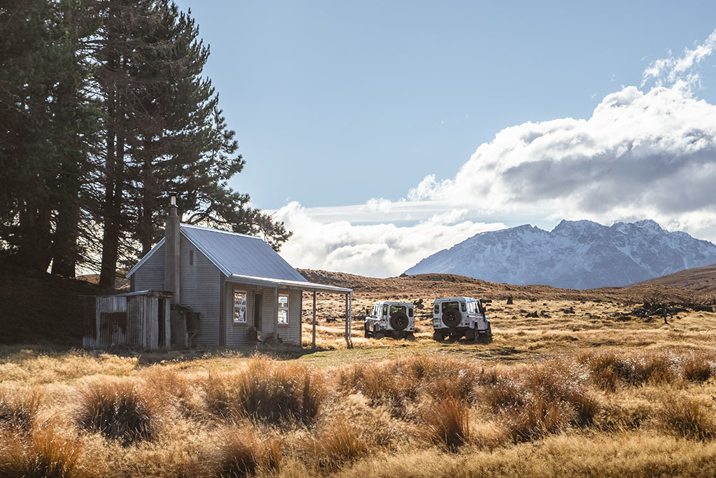 Braemar Station Farm Tour - 2 Land Rovers and a farm hut in a tussock paddock